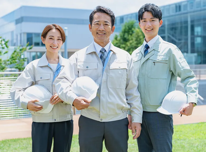 ヘルメットを持つ現場スタッフの集合写真